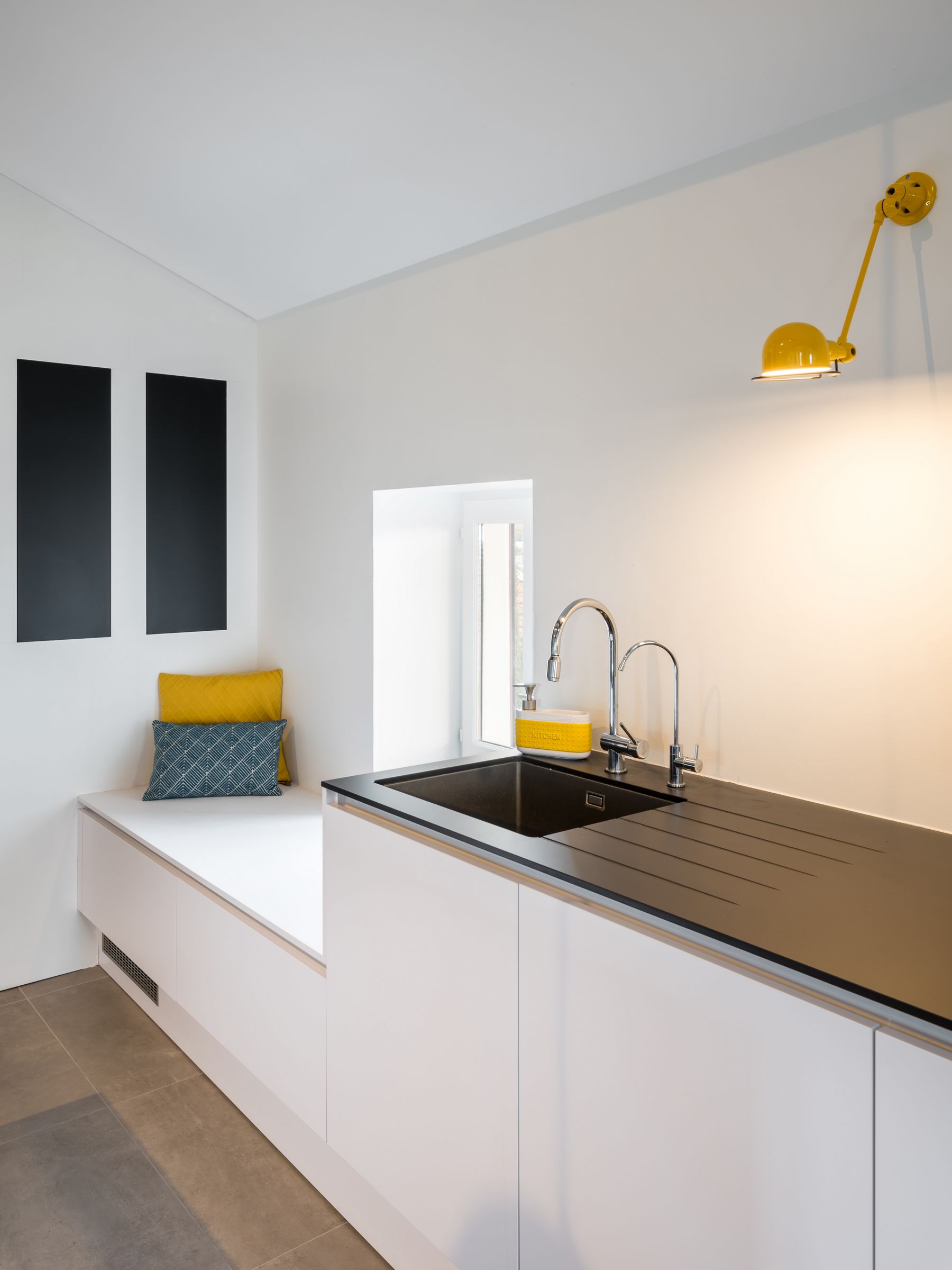 banquette dans cuisine blanche et noire avec decoration jaune par annie mazuy archietcte interieur a lyon