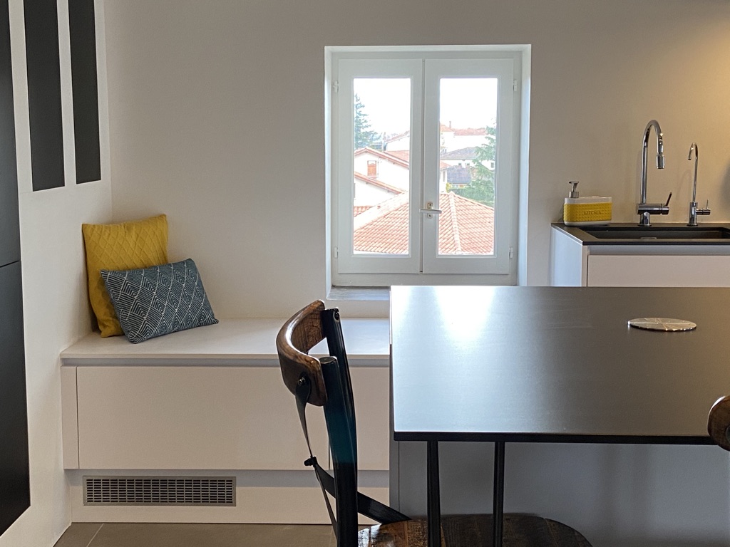 plan de travail noir en ceramique avec prises sur plan et banquette sous la fenetre par april moon home edition et annie mazuy architecte intereiur a lyon